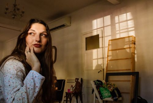 Free Young woman in a cozy room, thoughtful with warm sunlight casting shadows. Stock Photo