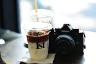 Retro Camera with Iced Coffee on Cafe Table