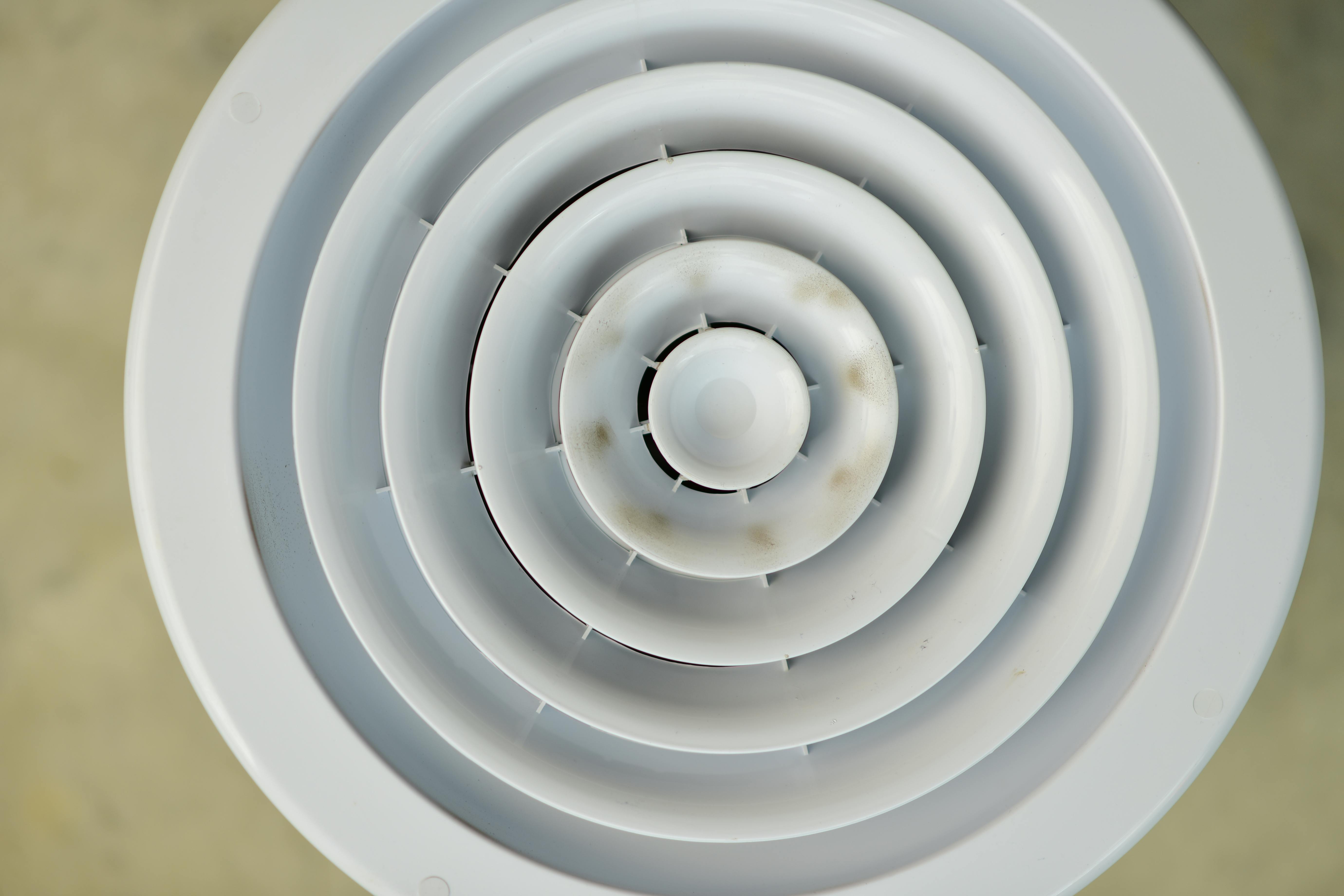 grátis Vista superior de uma grelha de ventilação circular branca, destacando seu design concêntrico com leve descoloração. Foto profissional