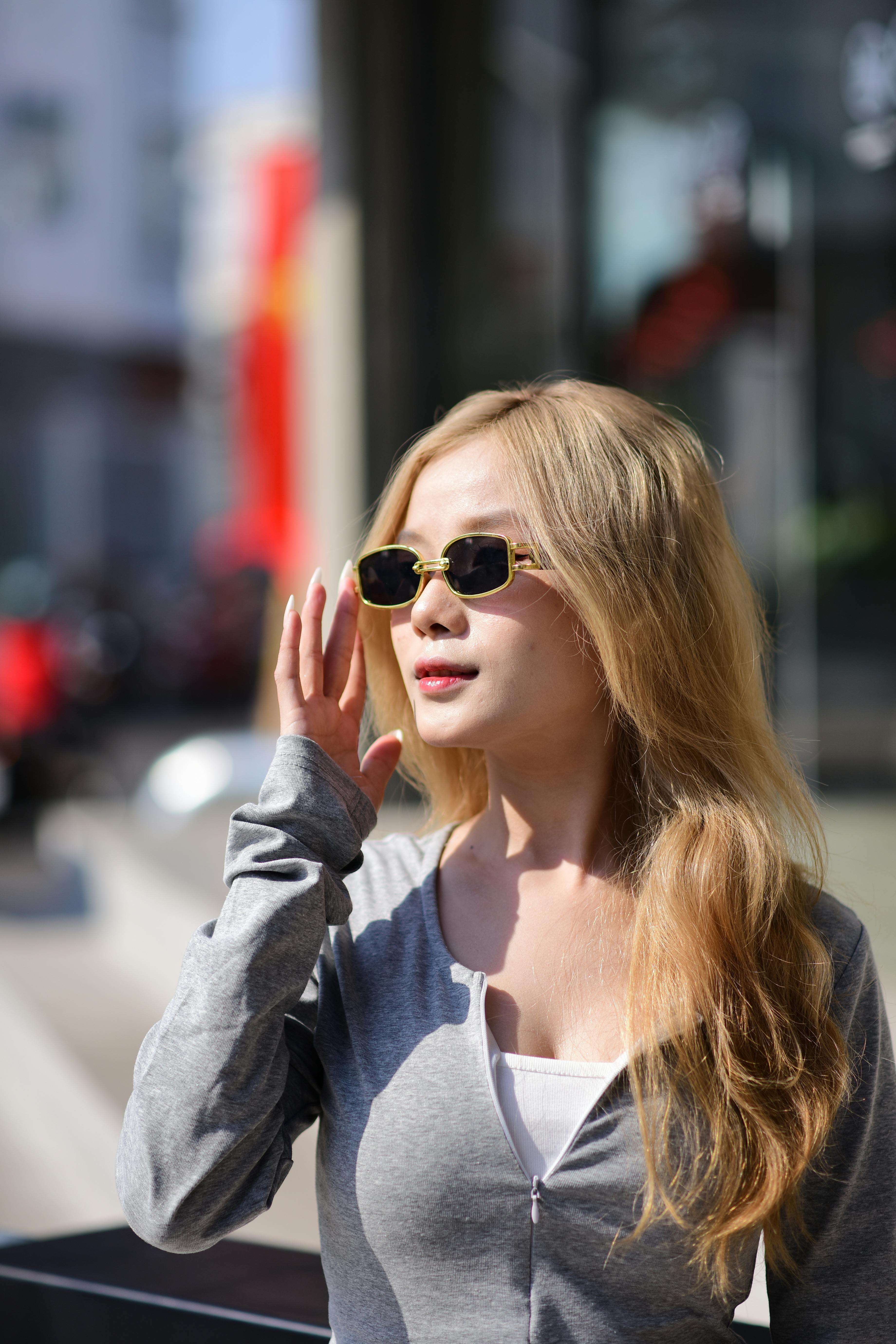 Free Young woman in sunglasses enjoying a sunny day in the city. Stock Photo
