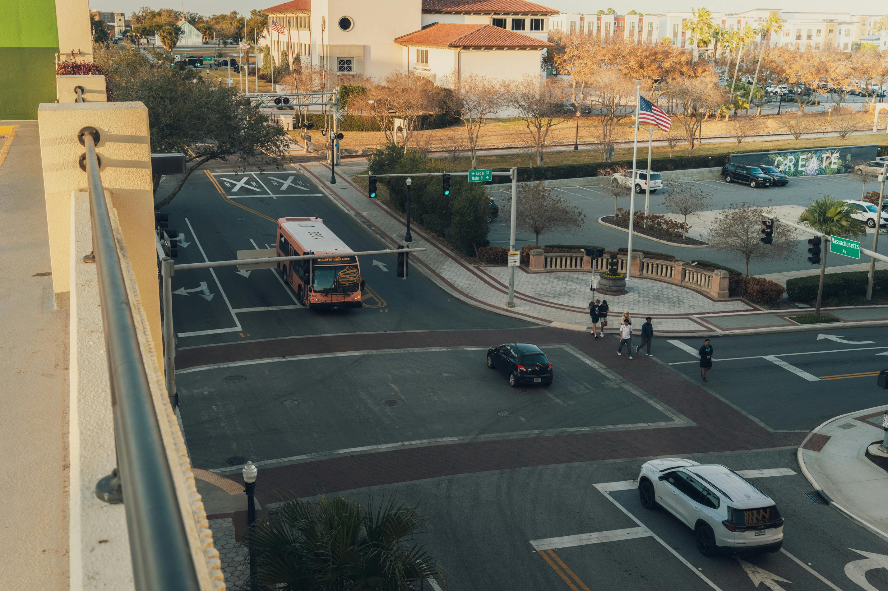 Aerial view of a busy street intersection in downtown with a bus and pedestrians crossing.