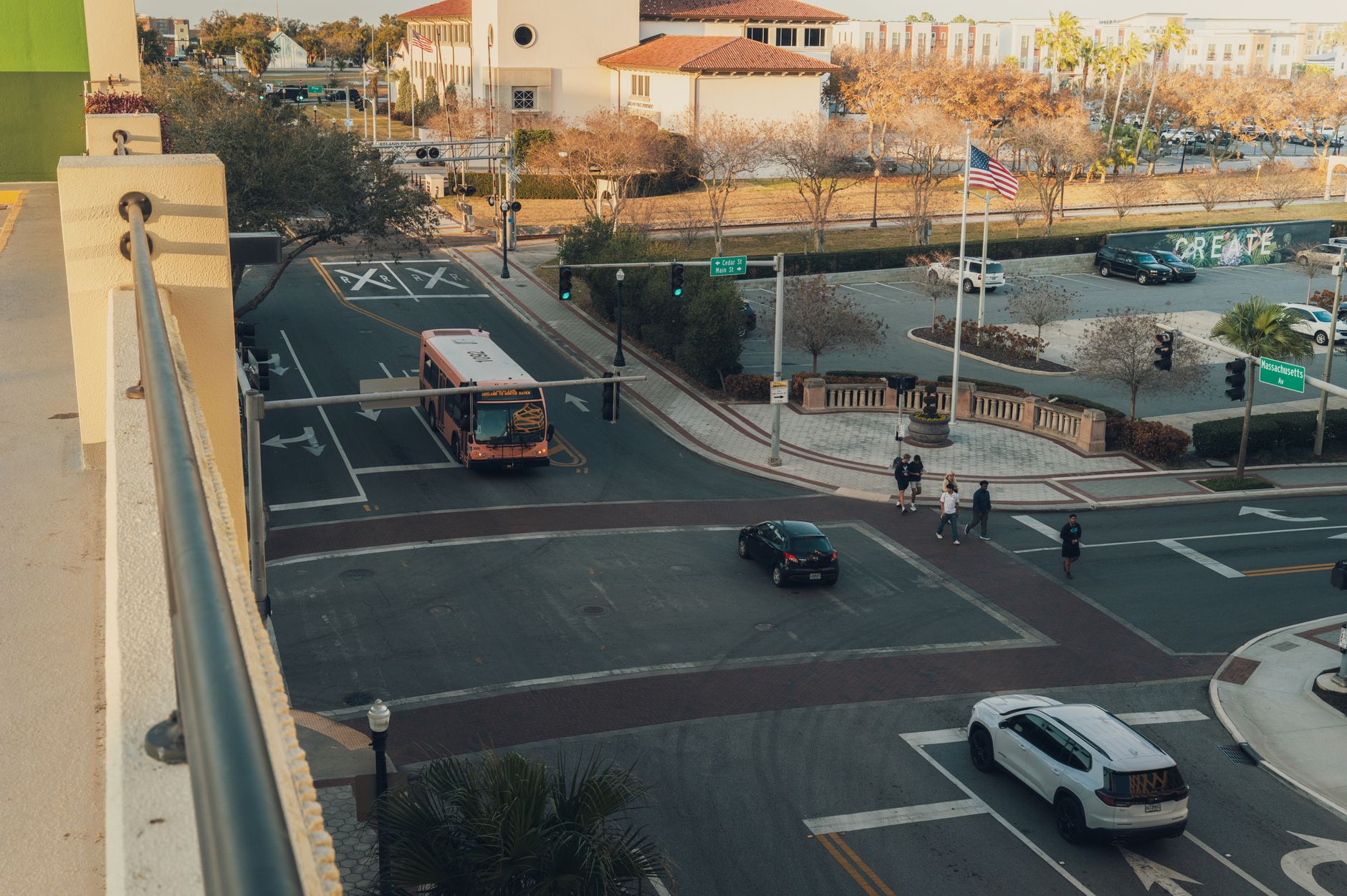 Aerial view of a busy street intersection in downtown with a bus and pedestrians crossing.