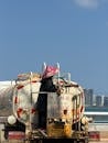 Worker on Water Tanker with City Skyline