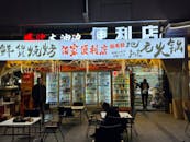 Nighttime Convenience Store Front in Bustling Area