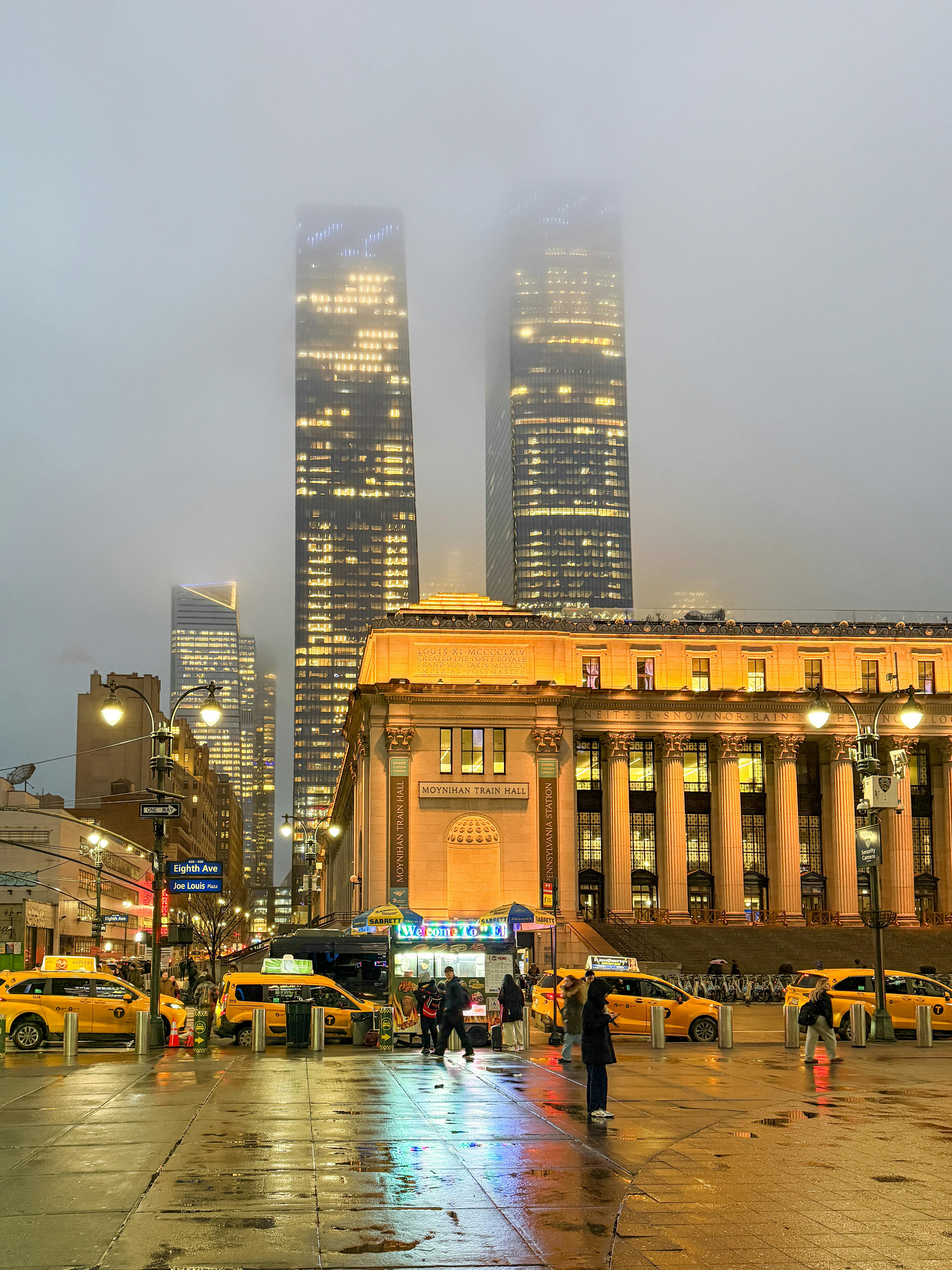 Δωρεάν Νυχτερινή άποψη του σταθμού Penn της Νέας Υόρκης με ομιχλώδεις ουρανοξύστες και κίτρινα ταξί. Φωτογραφία από στοκ φωτογραφιών