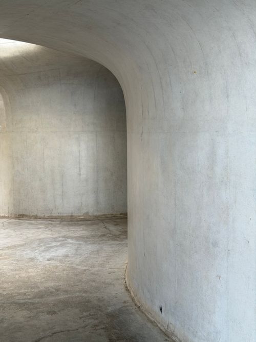 Free Curved concrete walls capture minimalist architecture. Ideal for modern design concepts. Stock Photo