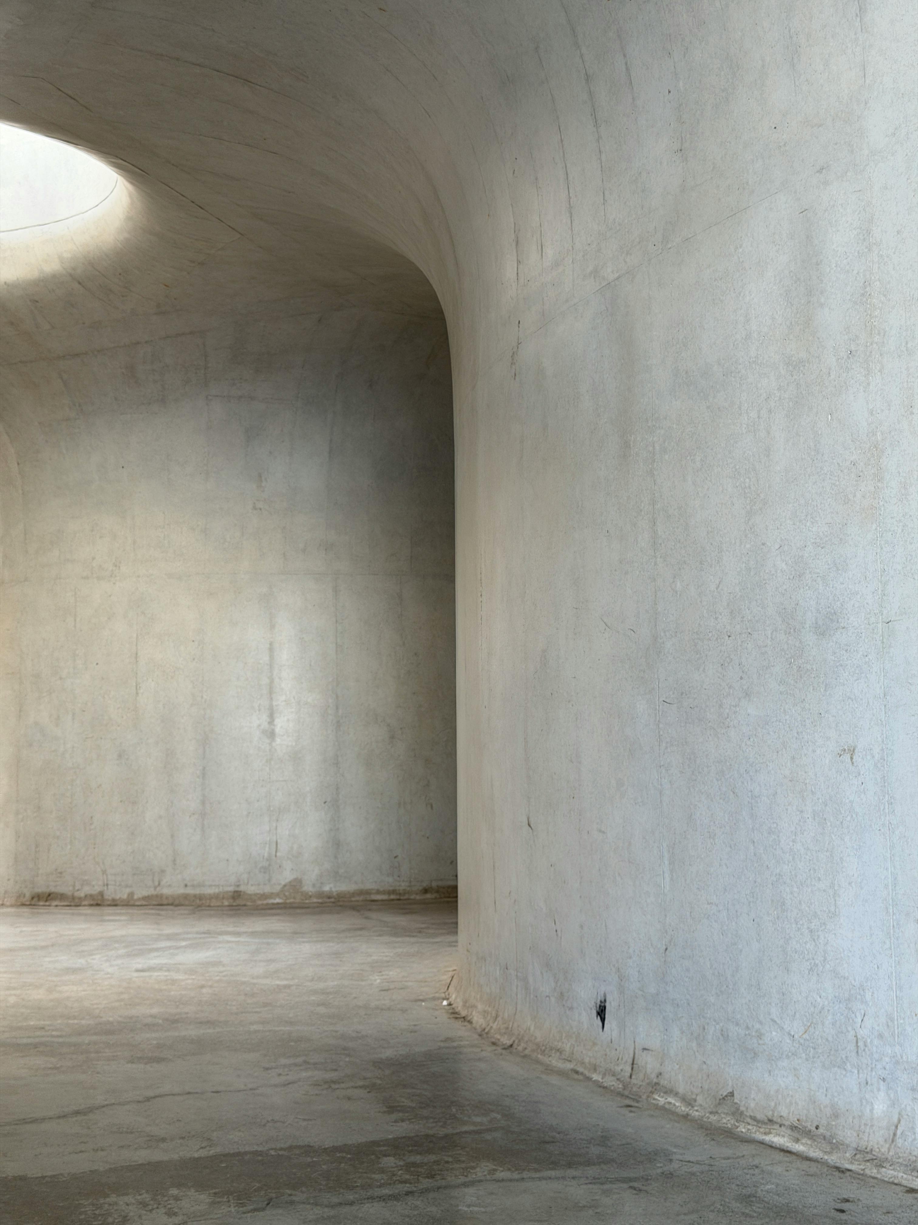 бесплатная Минималистичный дизайн интерьера с использованием бетона, демонстрирующий плавные линии и современную архитектуру. Стоковое фото