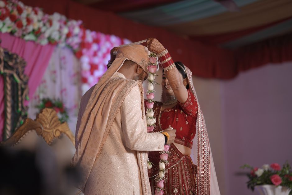 Bride and groom exchange garlands during wedding ceremony
