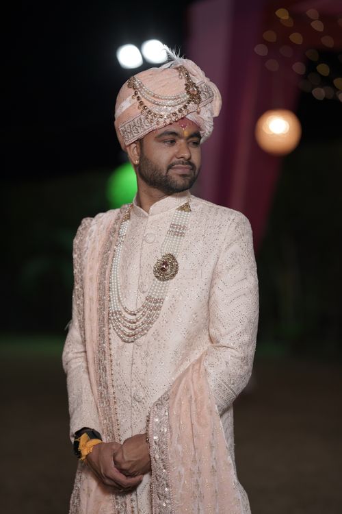 Free Portrait of a groom in lavish traditional Indian wedding attire, adorned with jewelry and a turban. Stock Photo