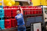 Worker Loading Propane Tanks onto Truck