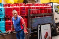 Man loading Petron Gasul cylinders onto truck