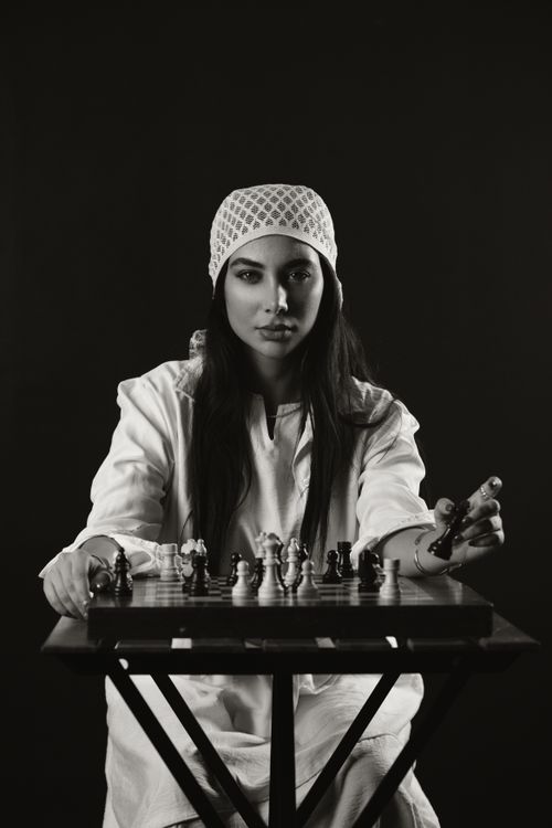 Free Black and white photo of a woman playing chess, intense and focused. Stock Photo