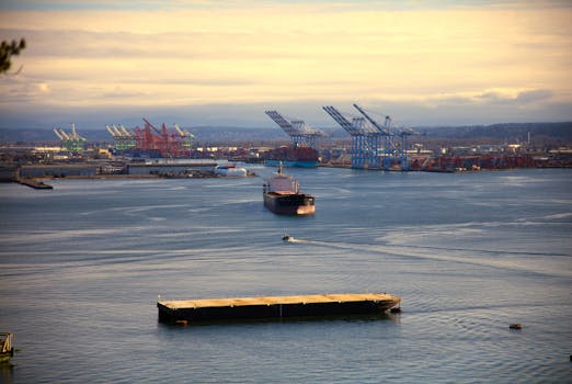 Aerial view of Tacoma Port with cargo ships and cranes under a blue sky.