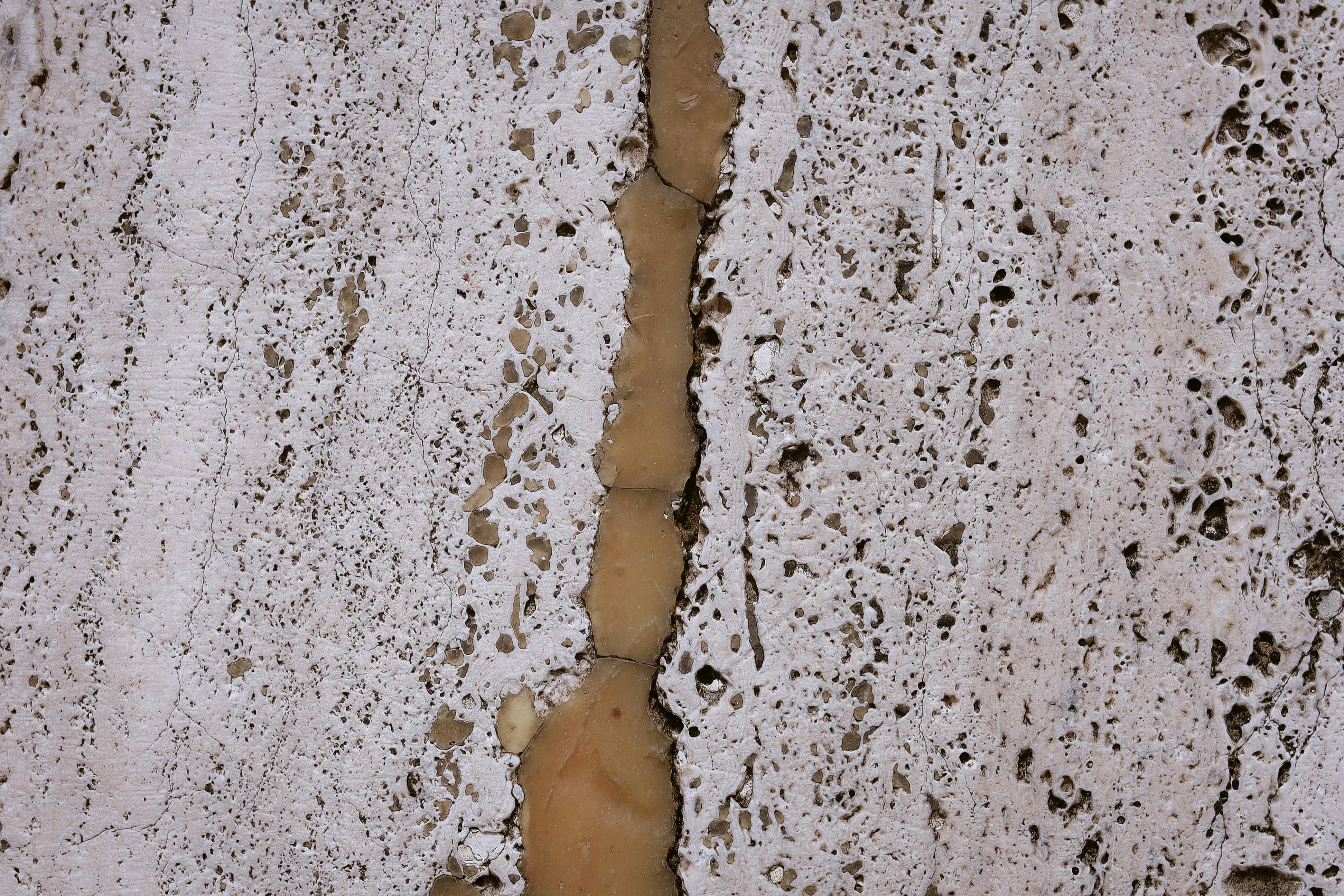 Gratis Immagine dettagliata che mostra la texture di una pietra usurata dalle intemperie, con fessure naturali e tonalità terrose. Foto a disposizione