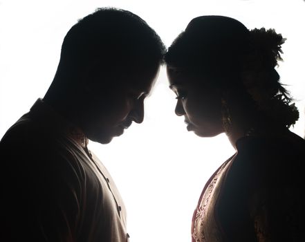 Silhouette of a couple sharing an intimate moment in traditional clothing.