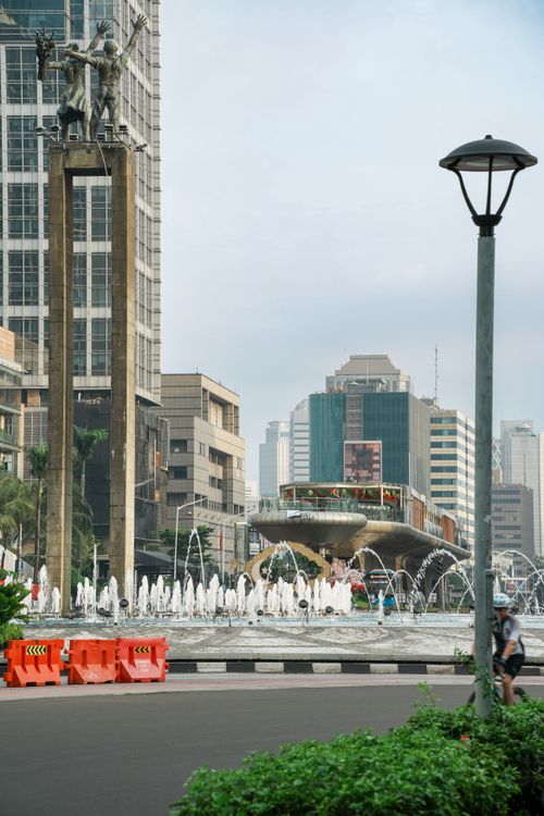 Free Scenic view of Welcome Monument and fountain at a bustling Jakarta street. Stock Photo