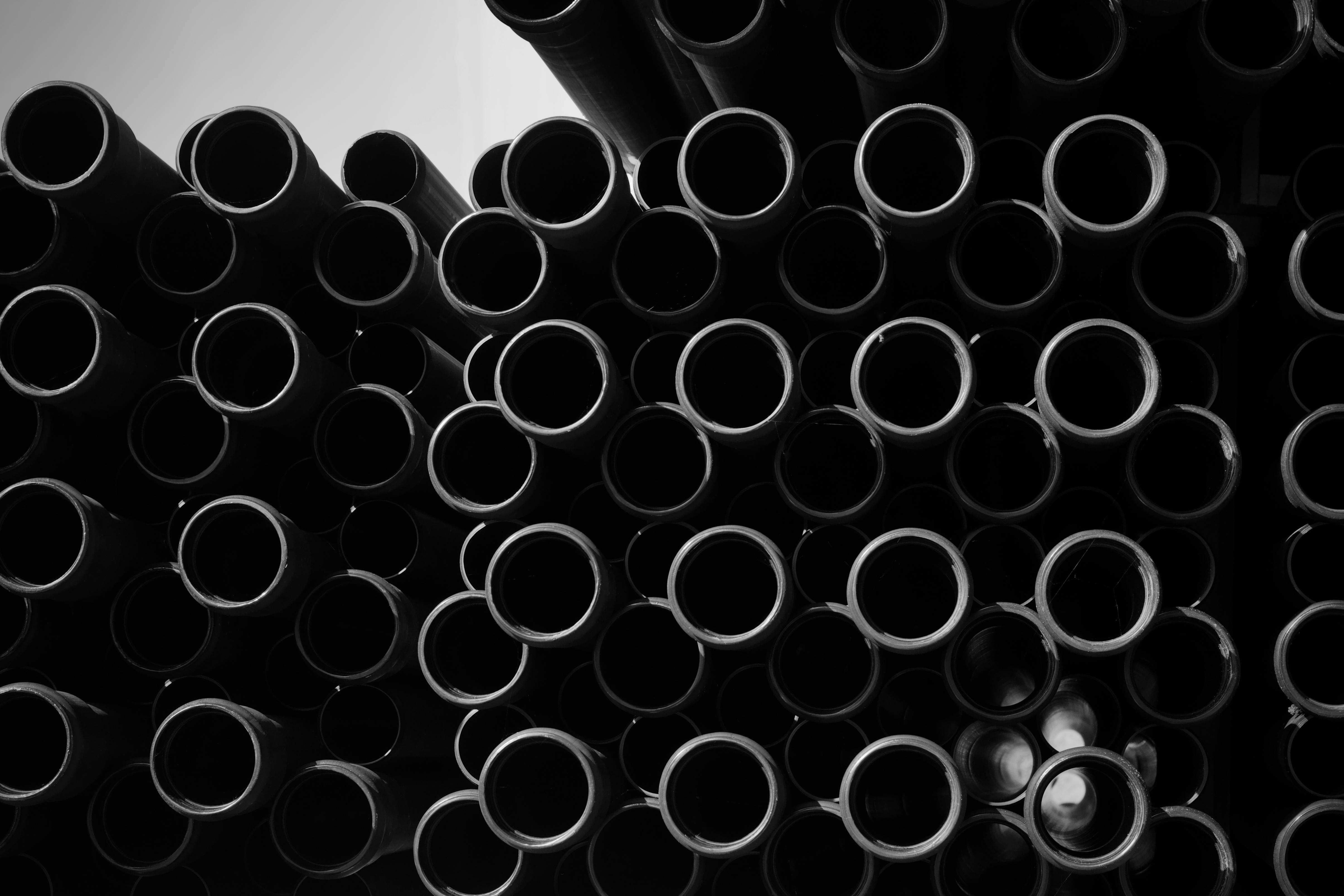Gratis Immagine artistica in bianco e nero di tubi industriali impilati per progetti creativi. Foto a disposizione
