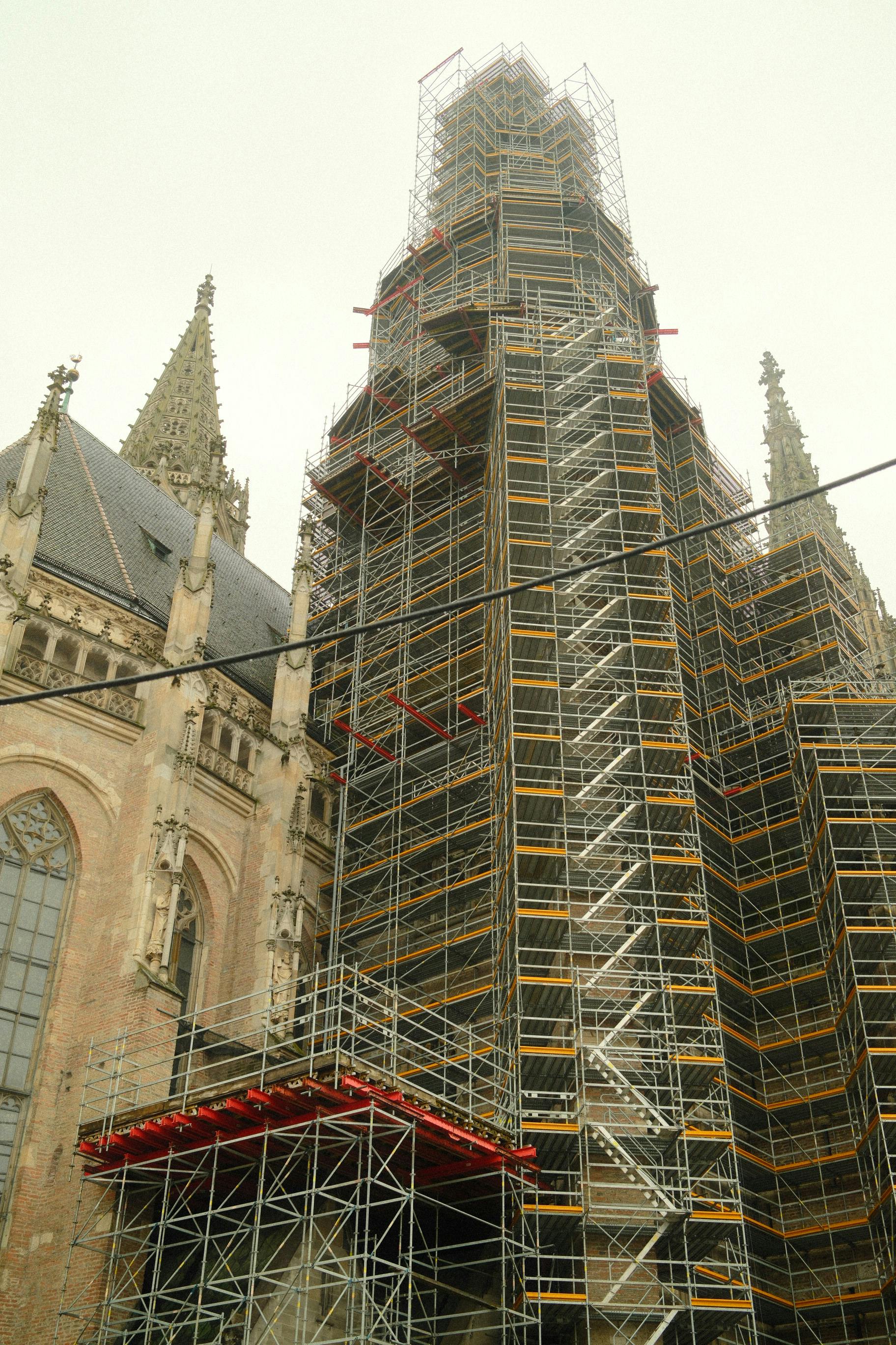 Δωρεάν Σκαλωσιές καλύπτουν τον ιστορικό πύργο του καθεδρικού ναού της Ουλμ στη Γερμανία, ο οποίος βρίσκεται υπό ανακαίνιση μια ομιχλώδη μέρα. Φωτογραφία από στοκ φωτογραφιών