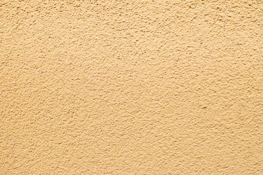 High-resolution image of a textured light yellow wall, perfect for backgrounds.