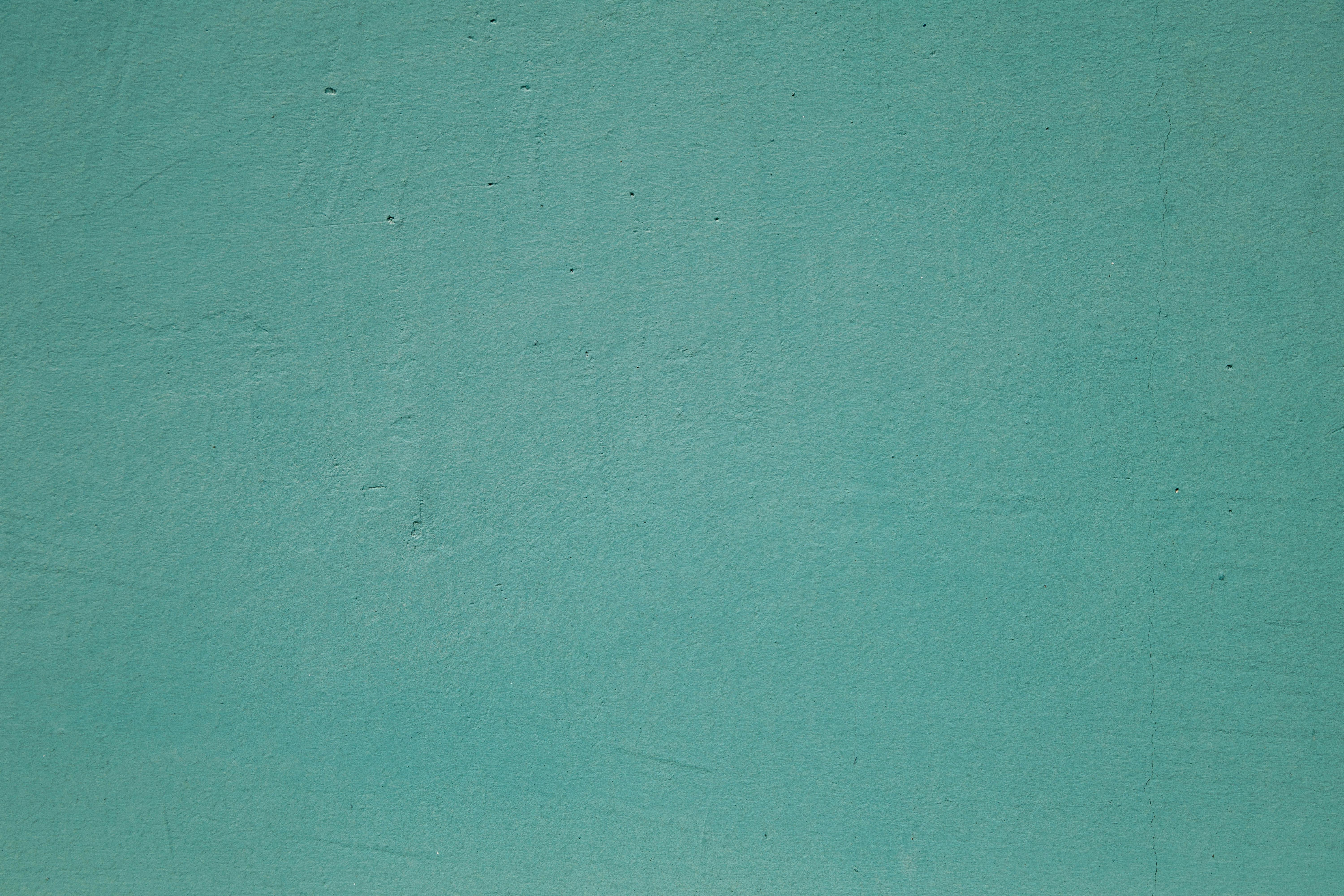 Free A simple and textured turquoise wall background, ideal for design projects. Stock Photo