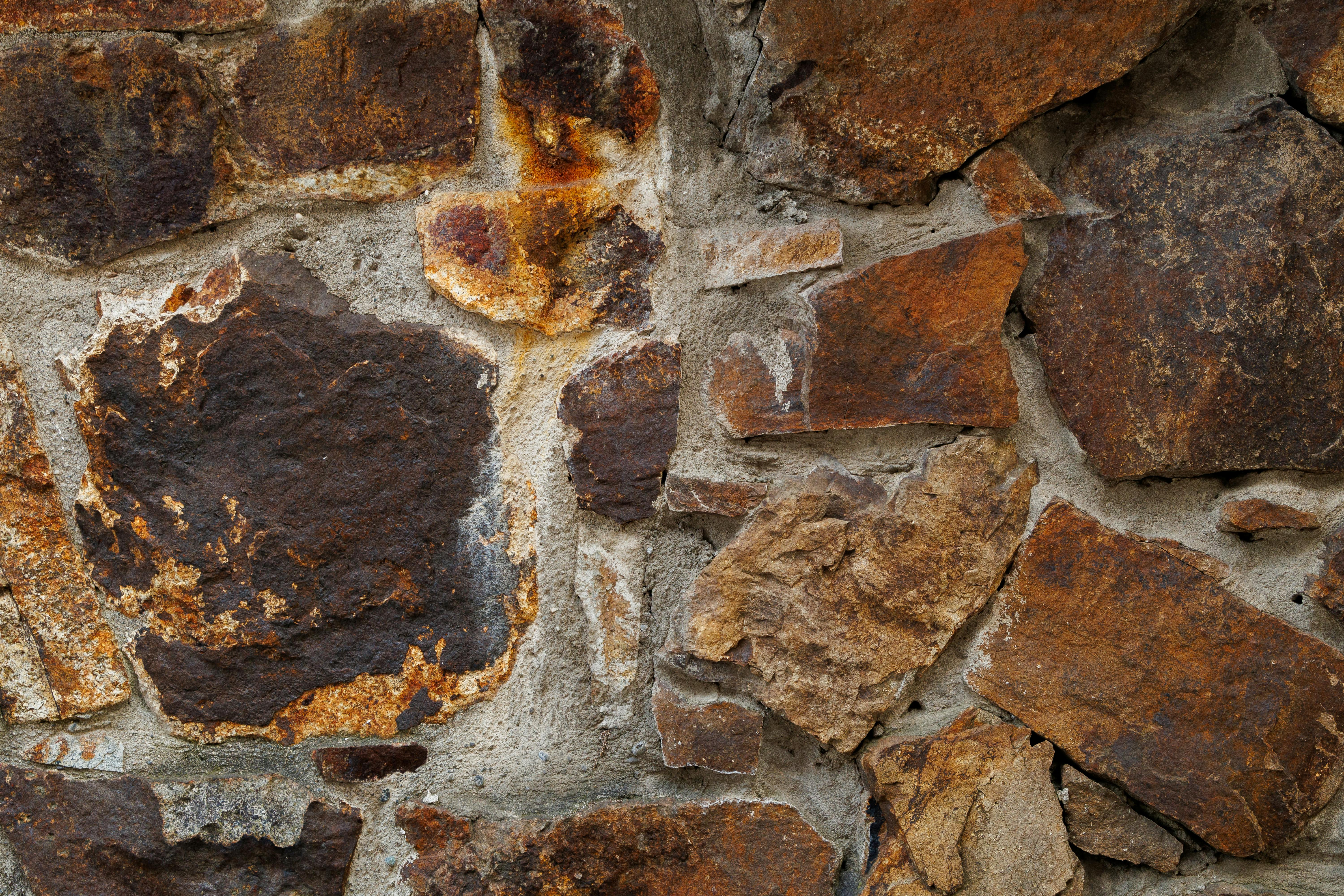 Δωρεάν Λεπτομερής άποψη μιας ρουστίκ υφής πέτρινου τοίχου που δείχνει φυσικά χρώματα και τραχιές επιφάνειες. Φωτογραφία από στοκ φωτογραφιών