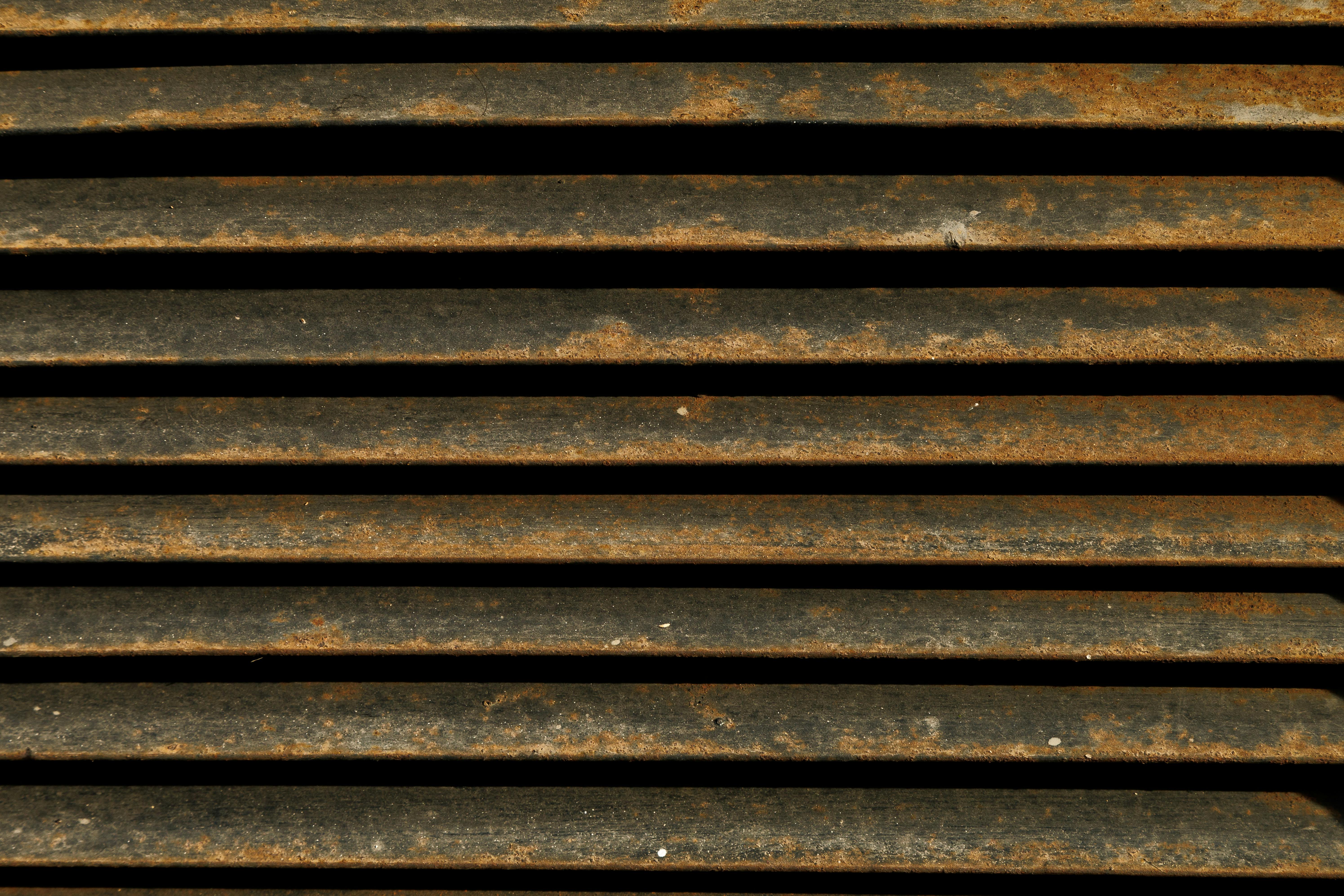 gratis Gedetailleerde close-up van een roestig metalen rooster met kenmerkende patina en texturen. Stockfoto