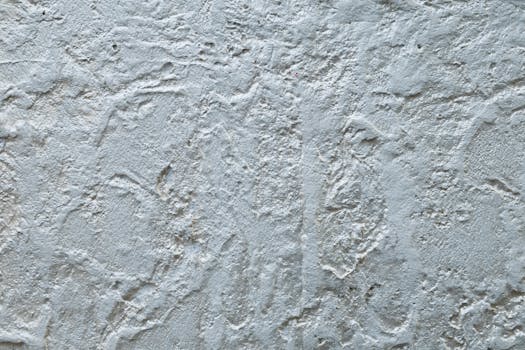 Close-up view of a textured white plaster wall, showing natural patterns and texture.