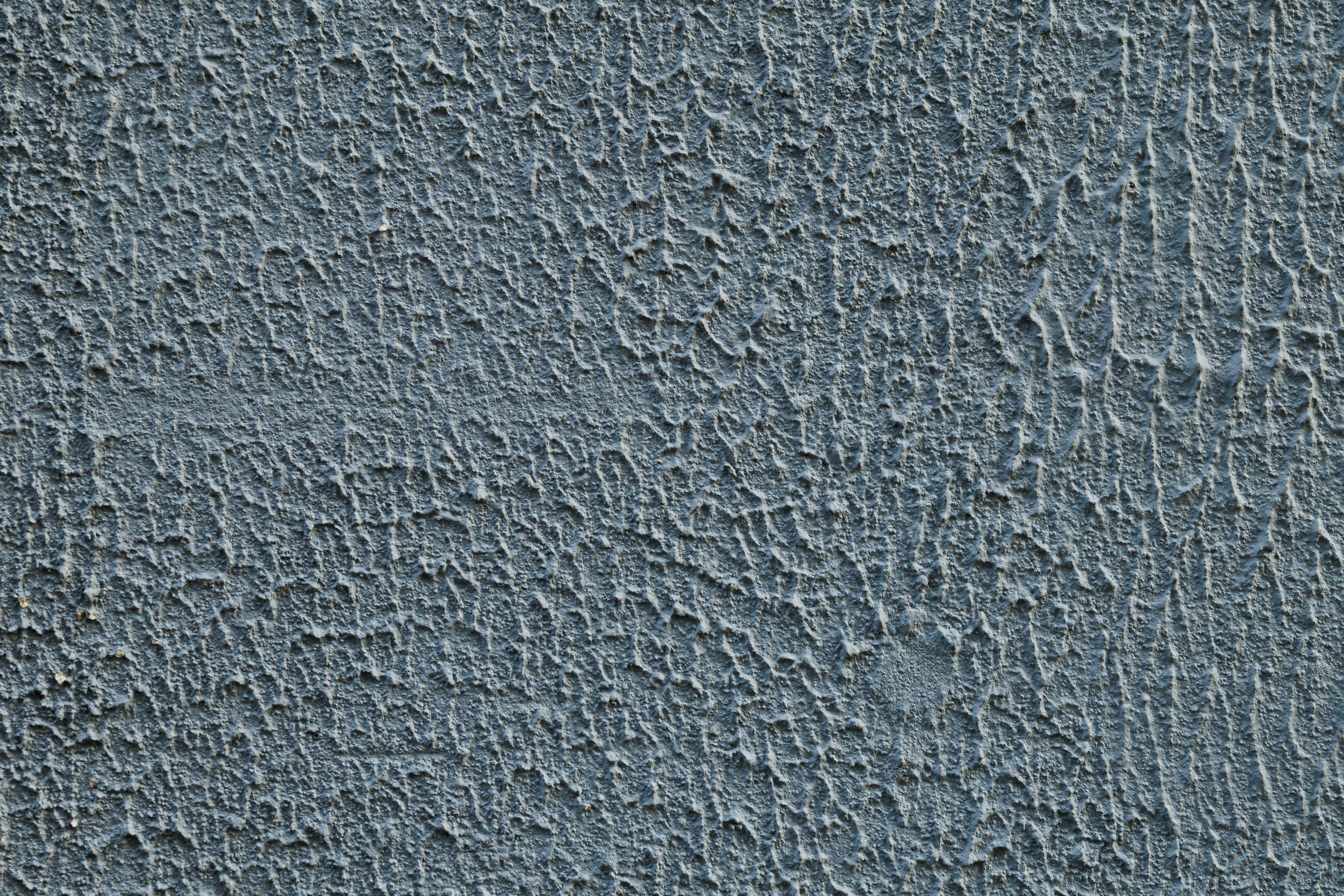 бесплатная Детальный крупный план фактурной бетонной стены, идеально подходящий для создания фона или текстуры. Стоковое фото