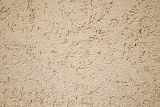 Detailed view of a beige stucco wall with rough texture, ideal for backgrounds.
