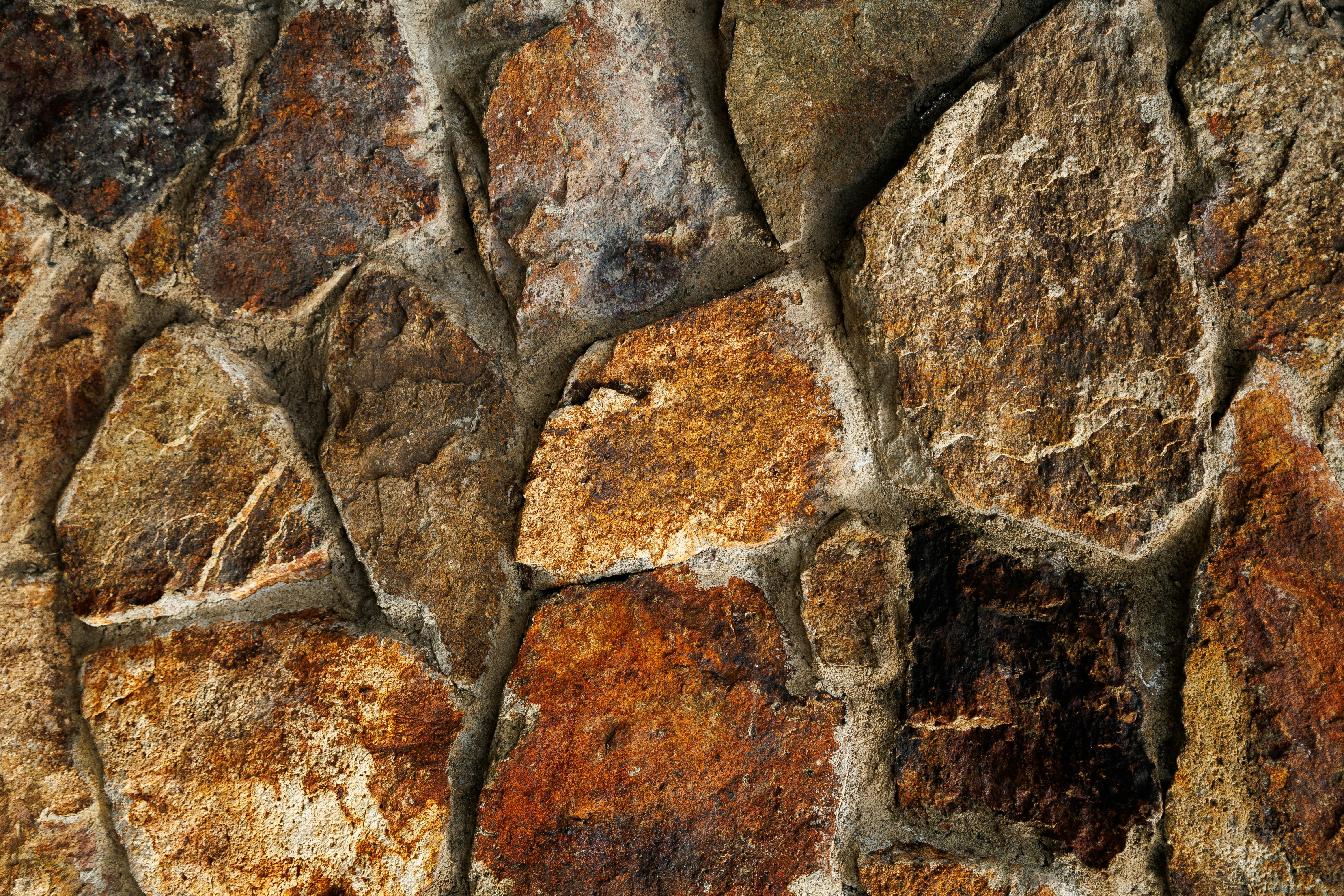 Δωρεάν Ένα περίπλοκο κοντινό πλάνο μιας υφής τοίχου από φυσική πέτρα, που αναδεικνύει γήινους τόνους και οργανικά μοτίβα. Φωτογραφία από στοκ φωτογραφιών