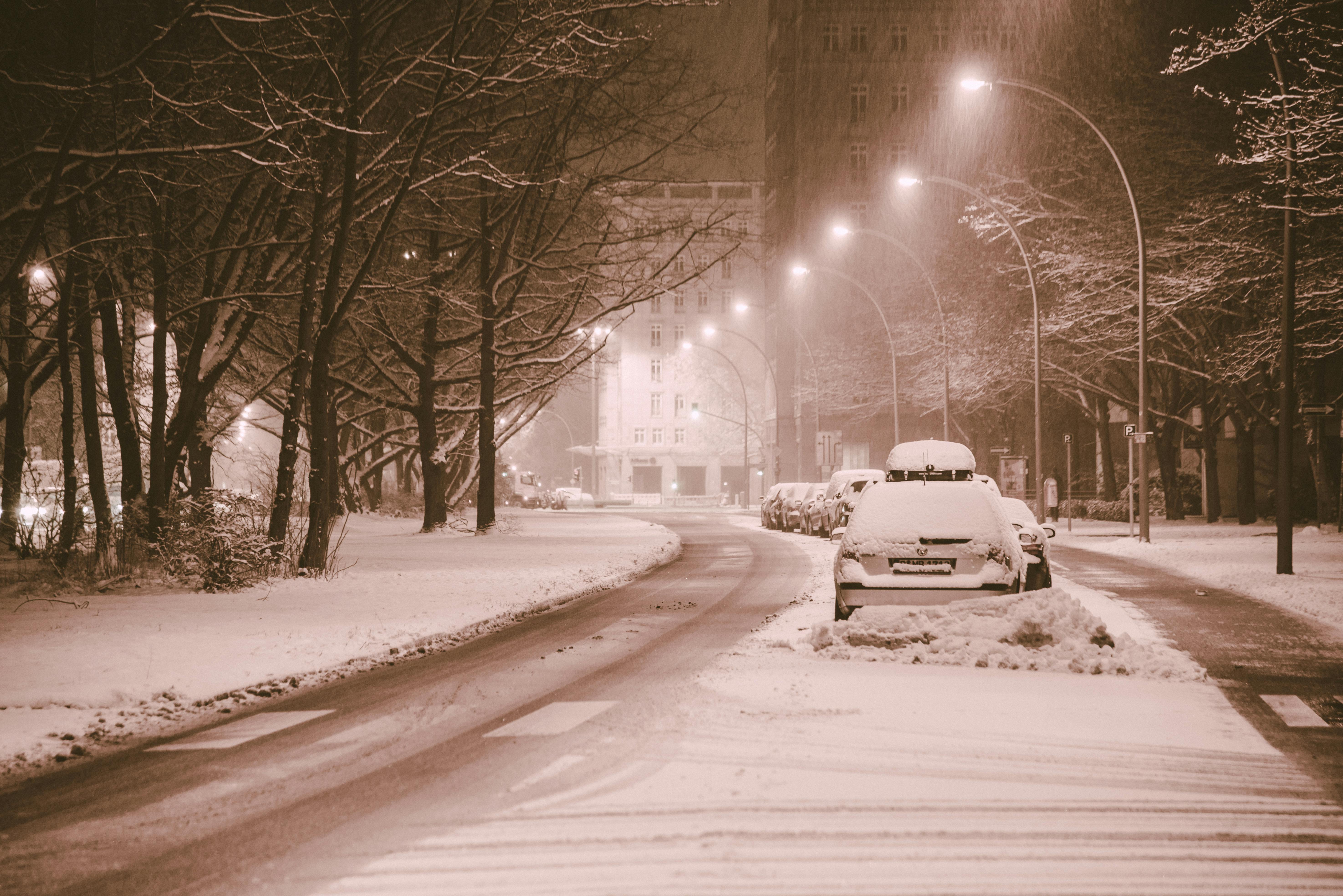 Δωρεάν Ένας γαλήνιος αστικός δρόμος καλυμμένος με χιόνι, φωτισμένος από φώτα του δρόμου, που αναδεικνύουν την γαλήνια ομορφιά του χειμώνα. Φωτογραφία από στοκ φωτογραφιών