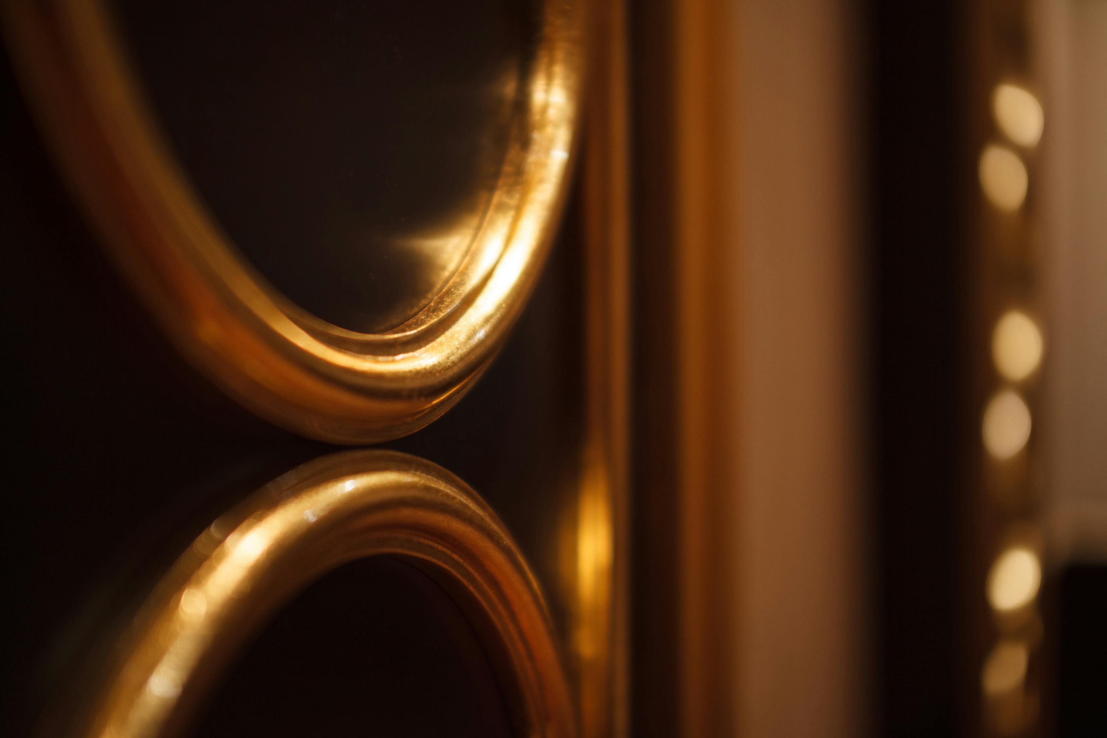 Free Close-up of gold oval frames reflecting warm ambient lighting, creating a luxurious mood. Stock Photo