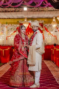 Traditional Indian bride and groom in festive attire at a wedding ceremony.
