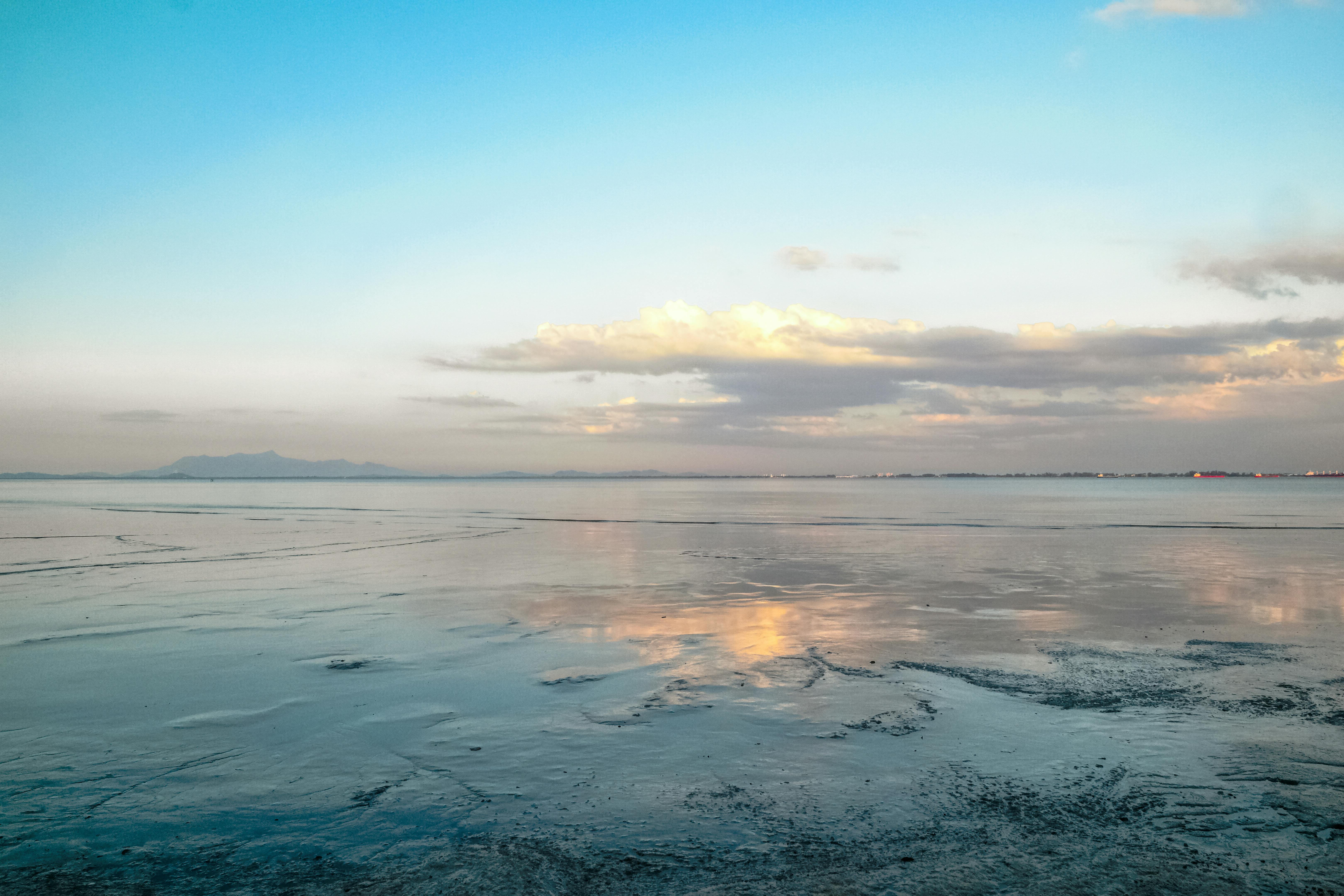 宁静的海景，平静的海洋和阴云密布的天空在日落时分