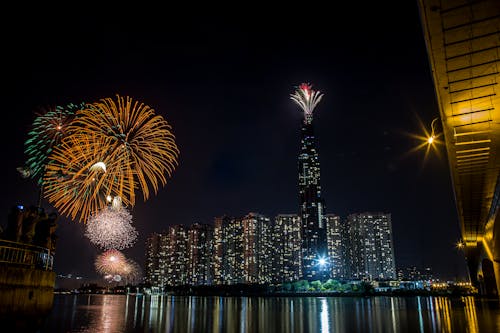 Free Fireworks Display Over City Buildings During Night Time Stock Photo
