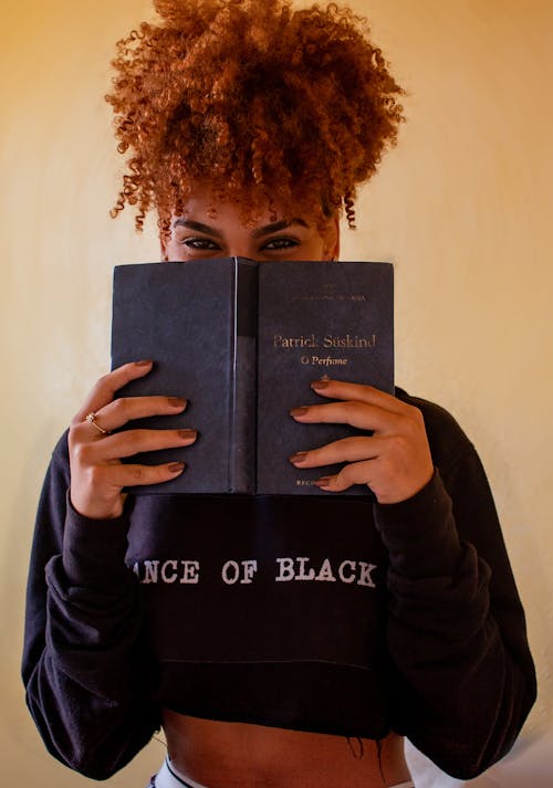 Woman Holding a Book in front of Her Face