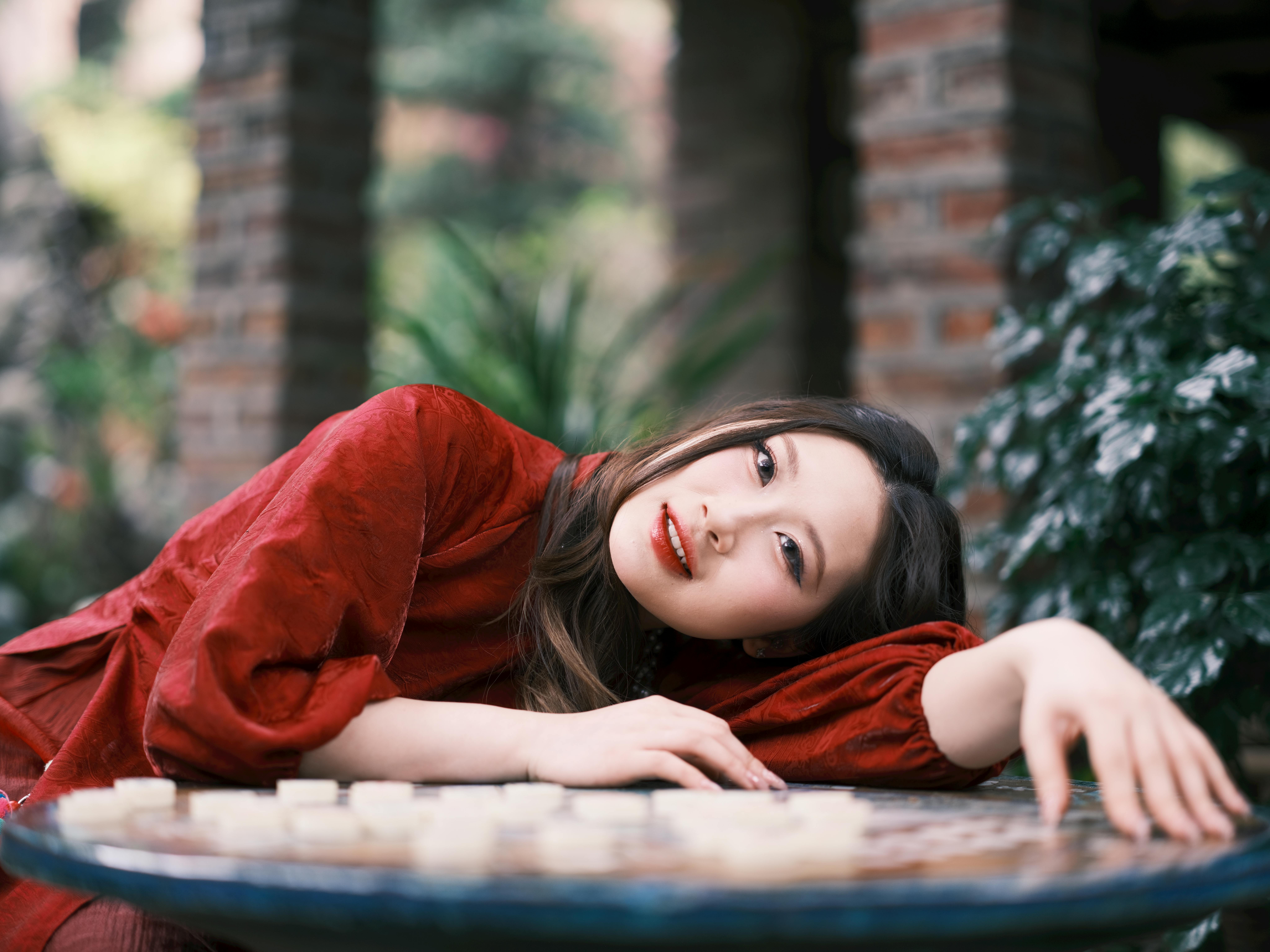 Woman in Red Dress Relaxing on Patio Table