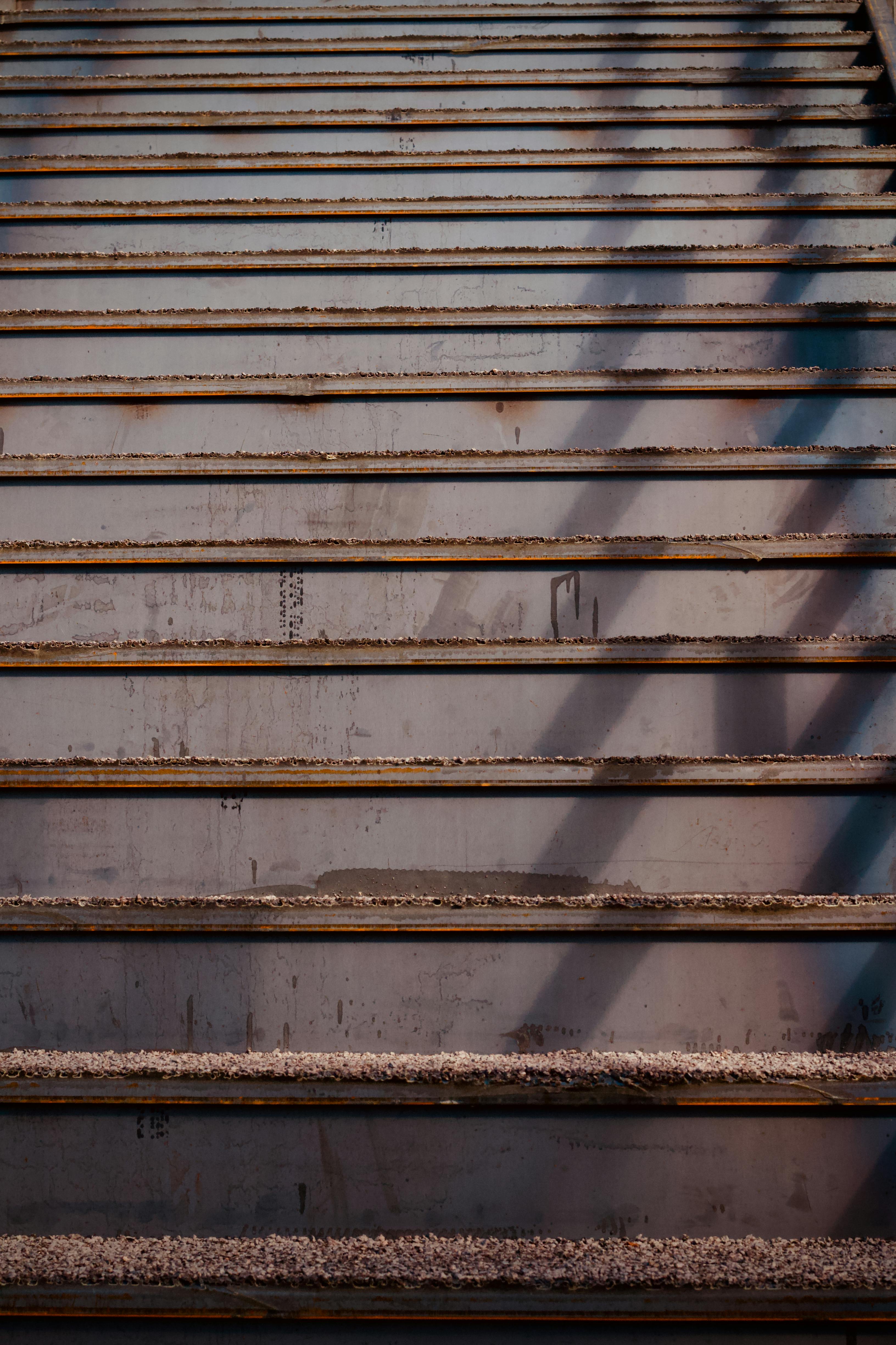 Δωρεάν Σκουριασμένες μεταλλικές σκάλες με σκιές που δημιουργούν ένα αφηρημένο μοτίβο. Φωτογραφία από στοκ φωτογραφιών