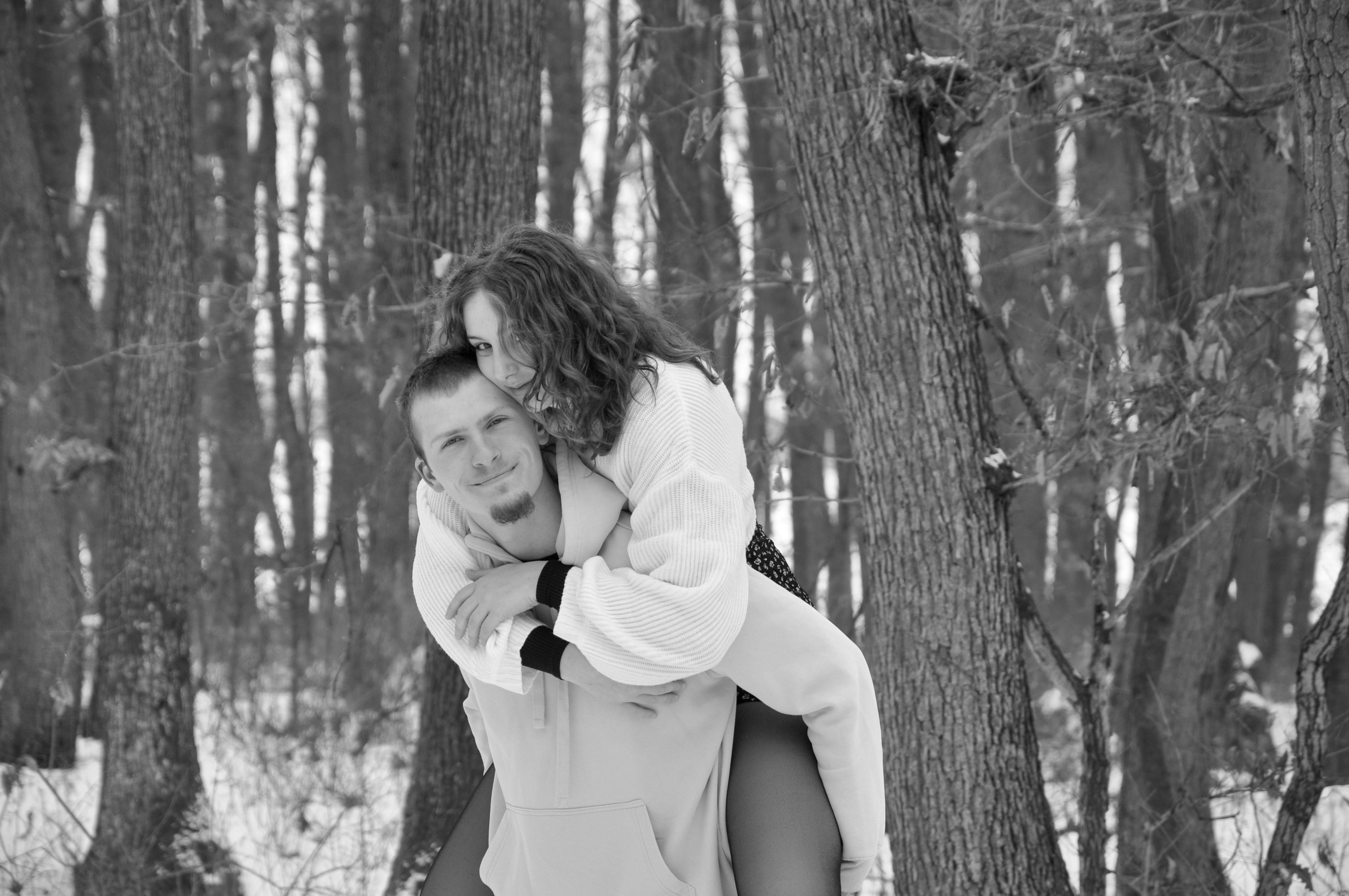 Kostenlos Ein glückliches Paar umarmt sich im verschneiten Wald und genießt einen freudigen Moment in der Winterzeit. Stock-Foto