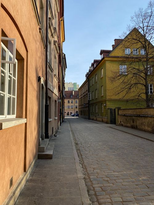 Free Picturesque street scene in Warsaw's Old Town with historic buildings and clear blue sky. Stock Photo
