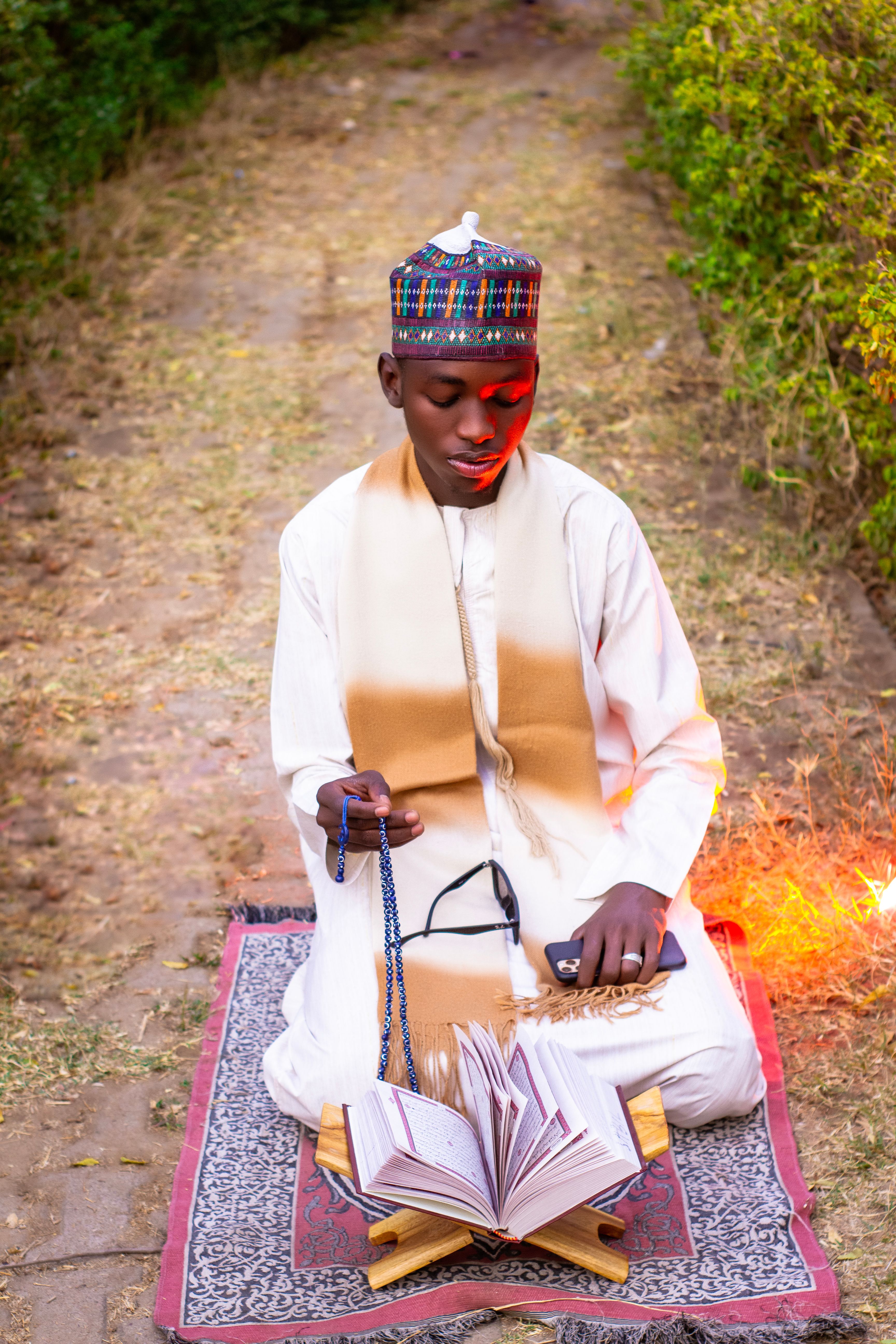 Young Man in Traditional Attire Praying Outdoors · Free Stock Photo