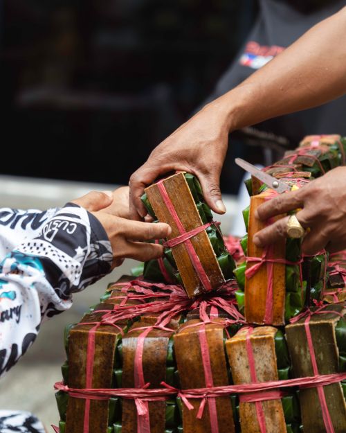 Free Close-up of a street food transaction showcasing wrapped snacks in a vibrant market setting. Stock Photo