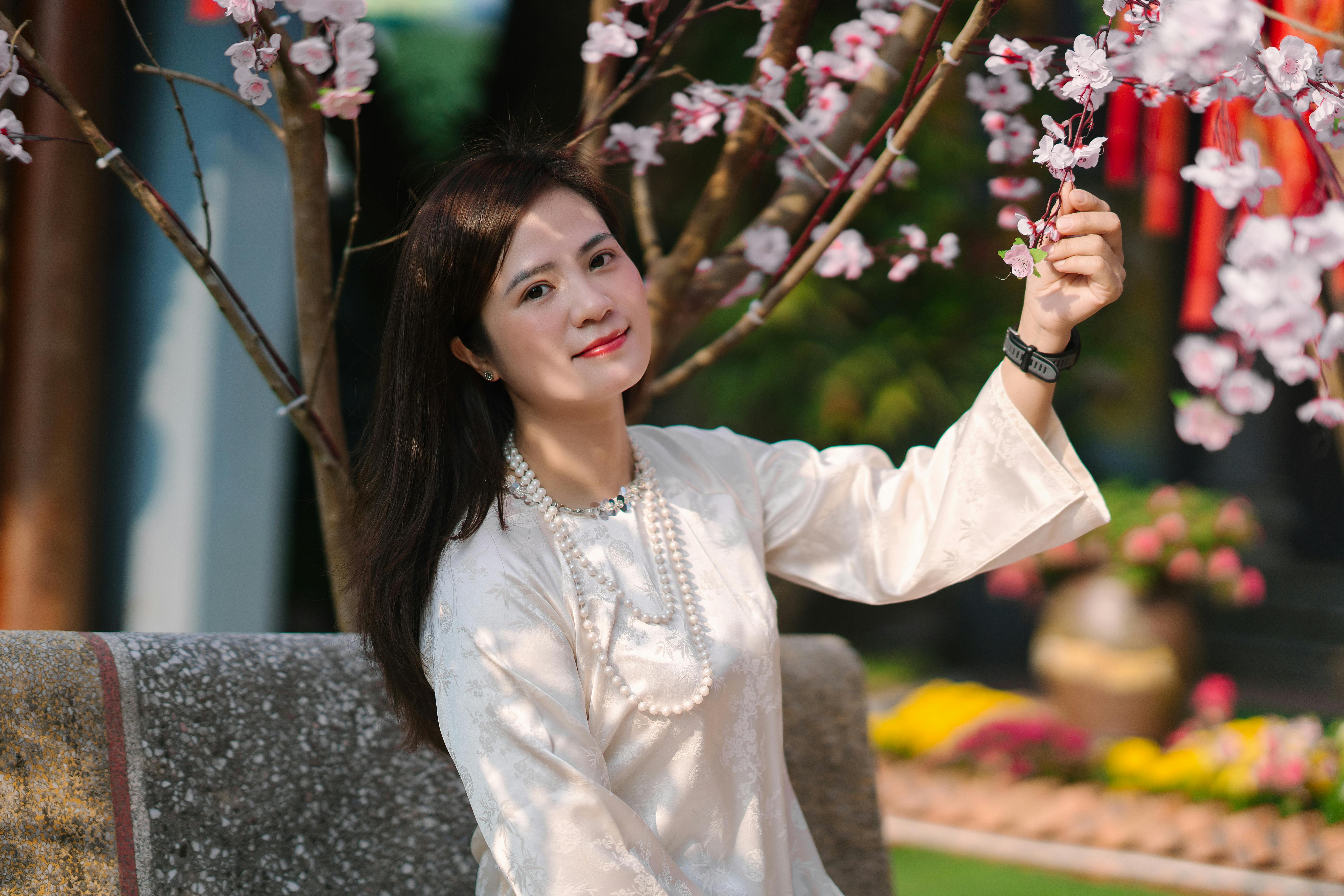 Smiling Woman in Traditional Dress with Cherry Blossoms