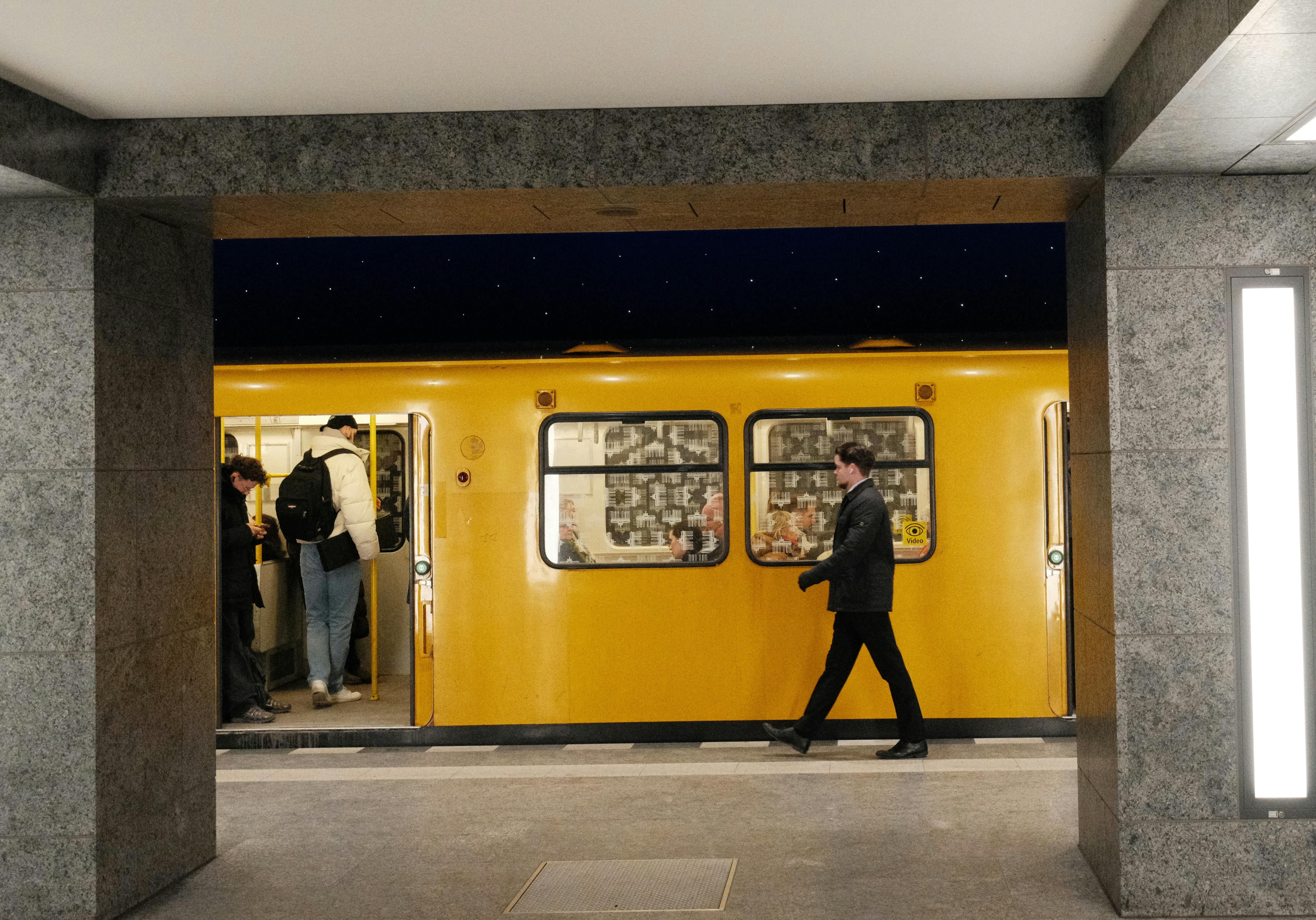 Δωρεάν Επιβάτες επιβιβάζονται σε ένα έντονο κίτρινο τρένο του μετρό σε έναν αστικό σταθμό του μετρό, φωτογραφημένο κατά τη διάρκεια της νύχτας. Φωτογραφία από στοκ φωτογραφιών