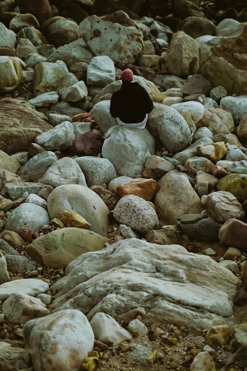 Photo of Person Sitting on Rocks