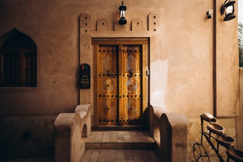 Free A beautifully adorned traditional Omani doorway in historic Nizwa Souq, showcasing intricate wooden design. Stock Photo