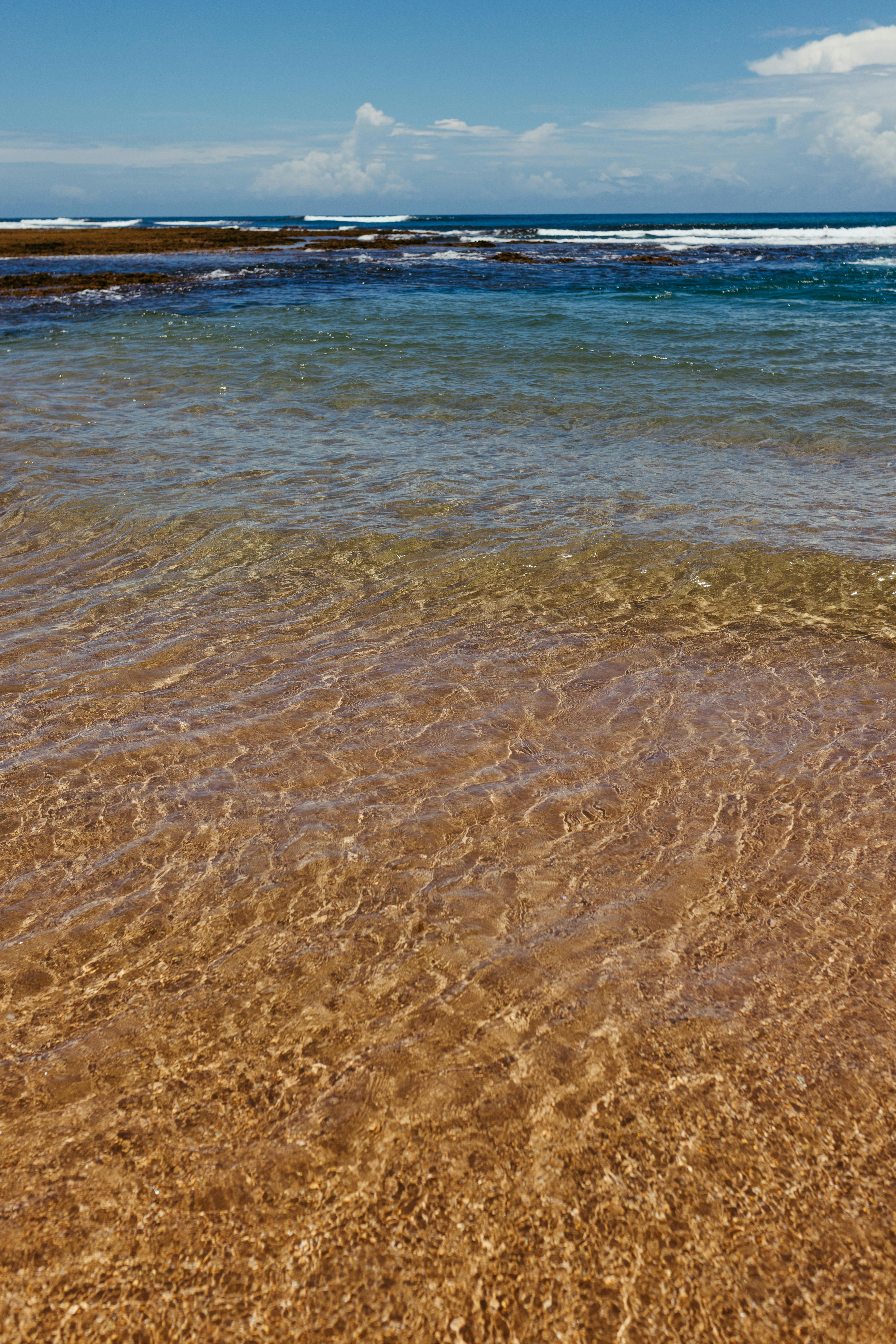 Kostenlos Wunderschöne Strandkulisse mit kristallklarem Wasser und strahlend blauem Himmel – perfekt als Inspiration für Reisen. Stock-Foto
