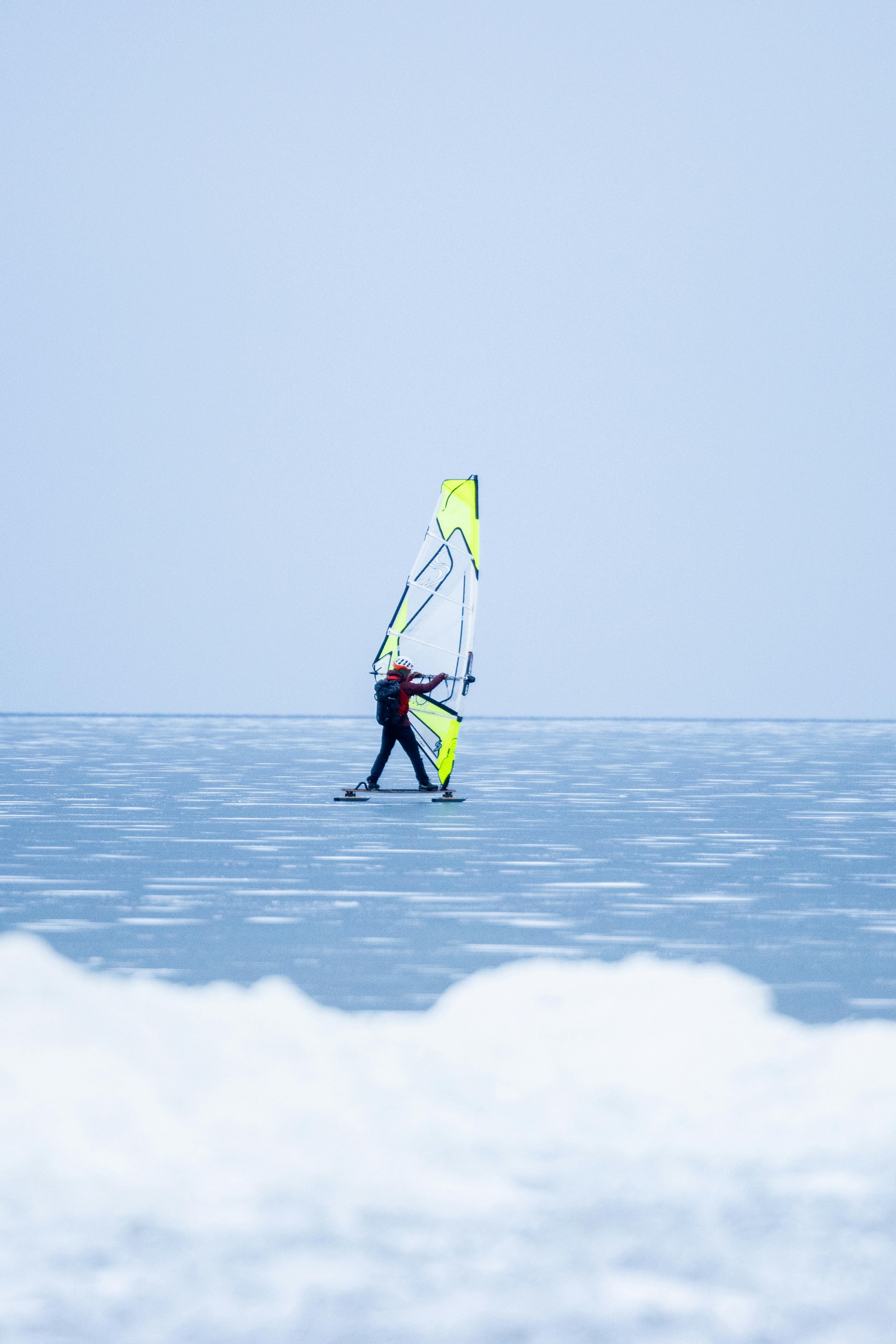 Gratis En windsurfer som navigerer gjennom en frossen innsjø i Jönköping, Sverige, viser vintersporteventyr. Arkivbilde