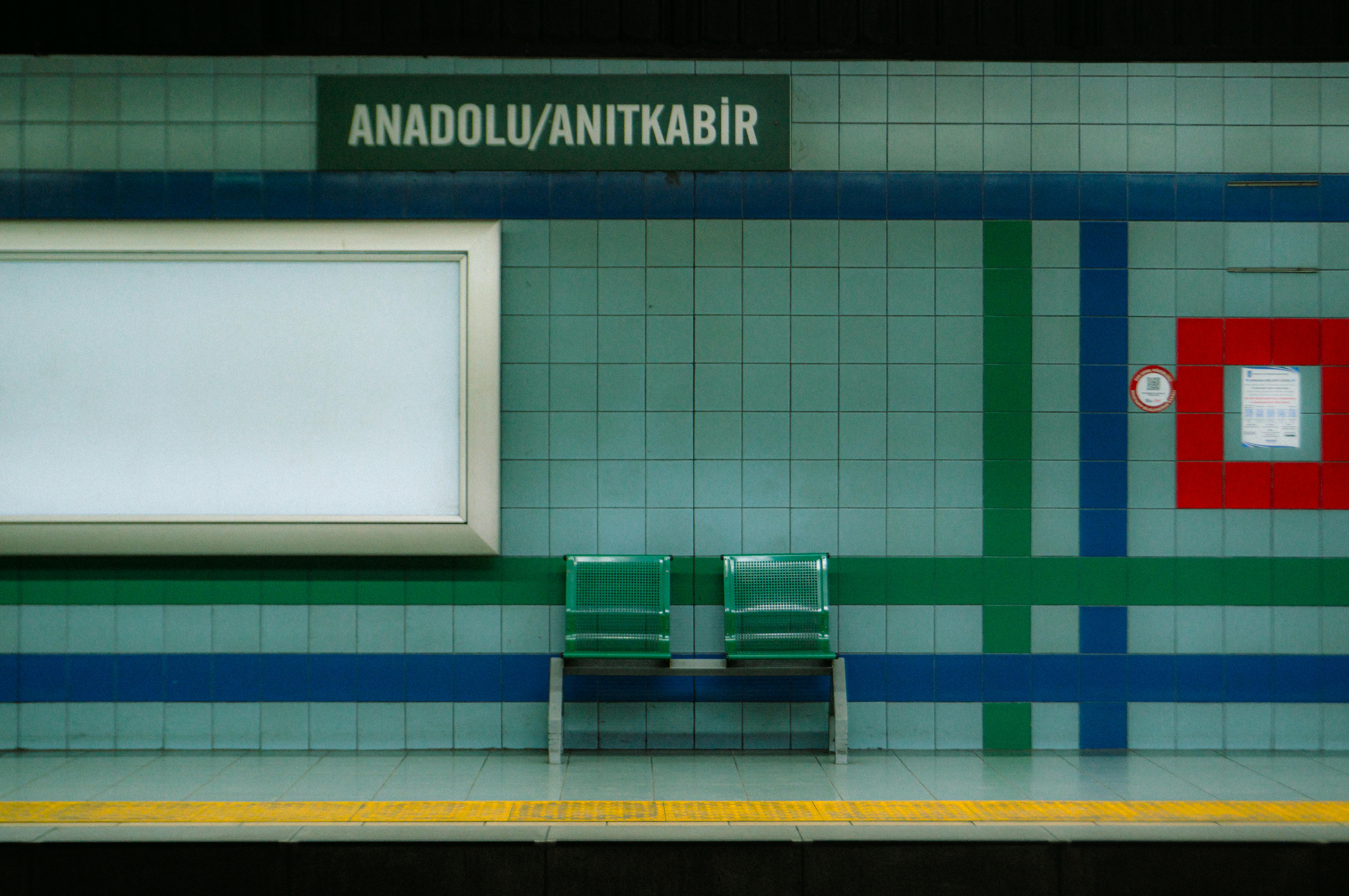 Calm metro station in Ankara, Türkiye with empty benches and colorful tiles.