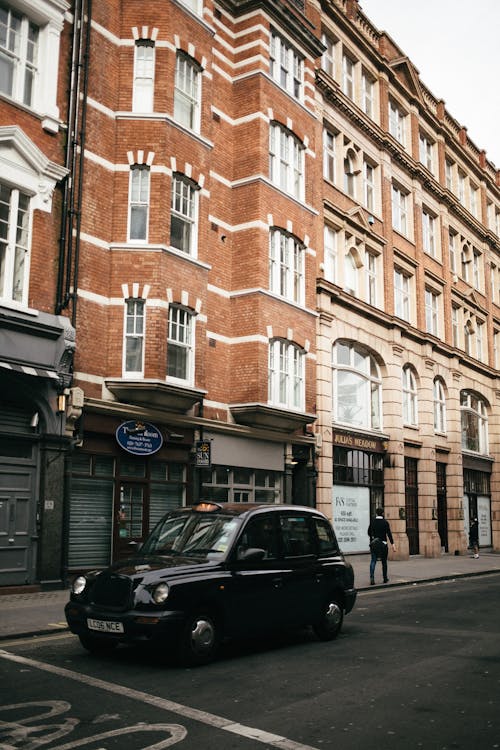 Black Car Parked Beside Brown Concrete Building